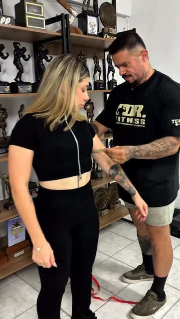 Rafael Calil medindo a circunferência do braço de uma aluna